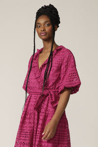 Close up of a model with braids wearing a fuchsia lace midi wrap dress with tie at waist
