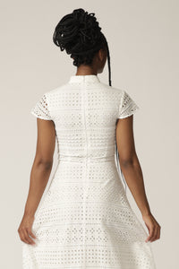 Back view of a model with braids wearing a white capped-sleeve lace dress