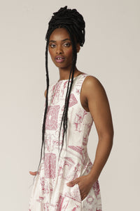 Close up of a model with braids wearing a boat-neck white midi dress with a red print