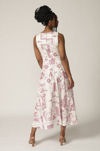 Back view of a model with braids wearing a boat-neck white midi dress with a red print
