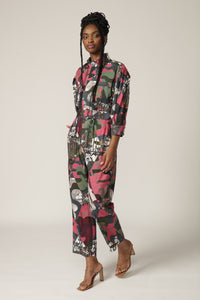 Model with braids wears a printed boiler suit with matching belt