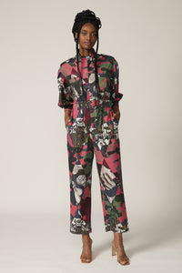 Model with braids poses in a printed boiler suit with matching belt