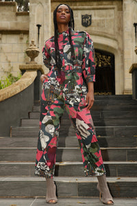 model with braids wearing a pattern boiler suit poses on ornate steps