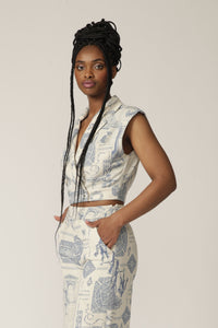 Model with braids poses in a sleeveless white and blue printed jacket with matching pants