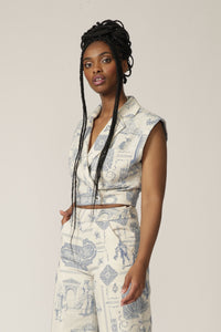 Close up of a model with braids wearing a sleeveless white and blue printed jacket with matching pants